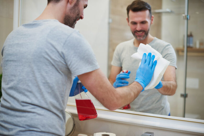person deep cleaning apartment bathroom scrubbing
